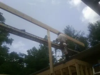 Carpenter setting a ridge beam over a new addition frame — Ice Dam Removal by Roofing Brothers in Dolphin