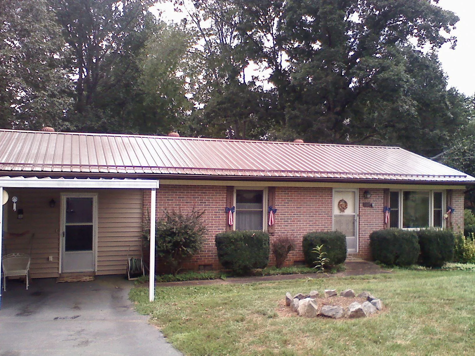 Bronze metal roof and carport on a brick ranch home — Roof Repair work by our crew in Dolphin